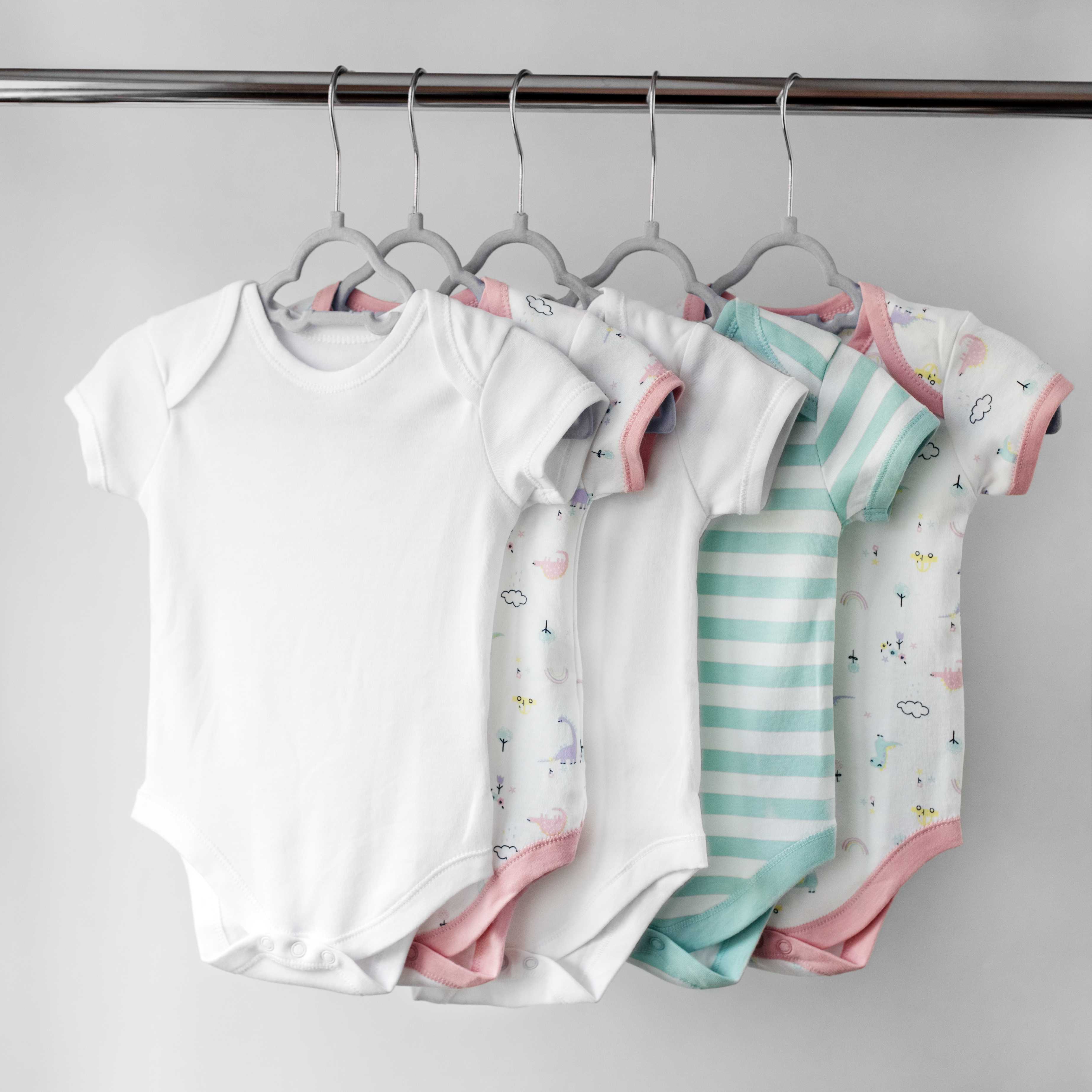 Clean baby clothes hanging on a rack