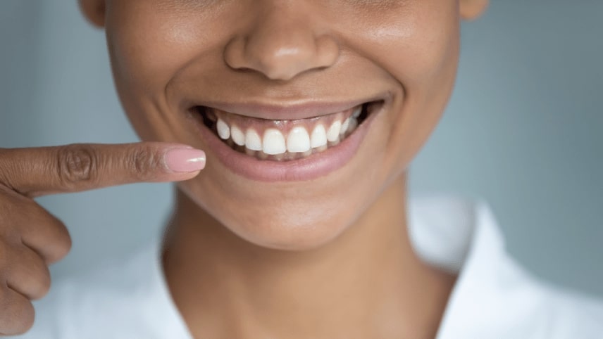 Woman pointing finger at healthy gums and teeth