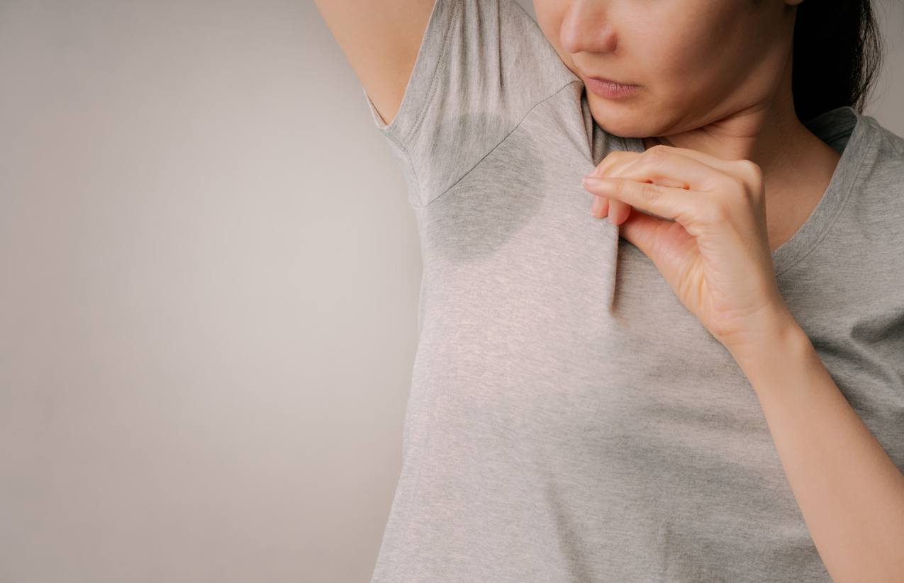 Woman showing off armpit sweat stain and smell