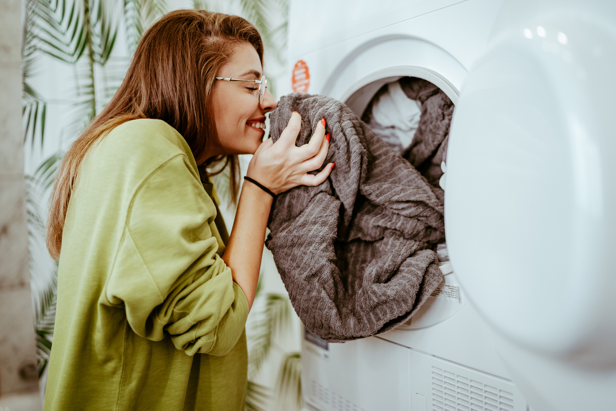 Woman smelling clean laundry 