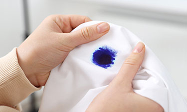 Blue ink stain on a white shirt.